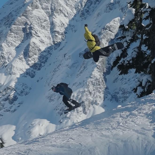 Nils and Hans hit a jump on snowboards